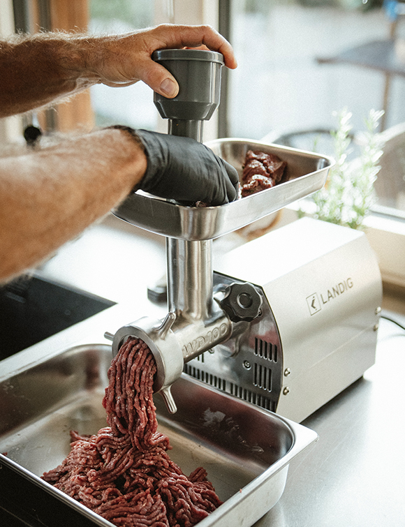 Mit einem Fleischwolf wird das Hackfleisch hergestellt